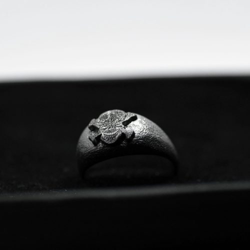 Ανδρικό δαχτυλίδι από ασήμι 925 βαθμών που έχει δεχθεί μαύρη επιπλατίνωση. Το δαχτυλίδι φέρει ένθετο έντεχνο χαρακτικό σχέδιο με νεκροκεφαλή. Μέρος για τη συλλογή Θυμήσου Σώμα