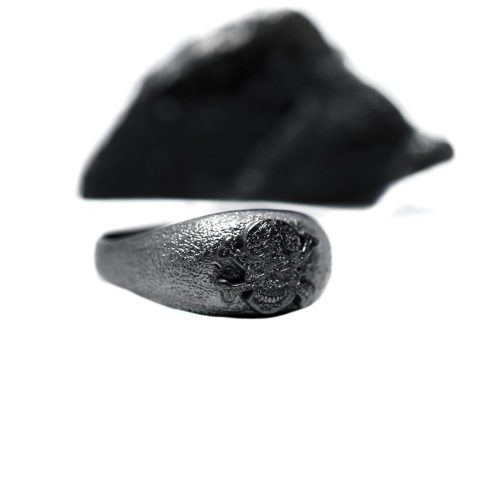 Ανδρικό δαχτυλίδι από ασήμι 925 βαθμών που έχει δεχθεί μαύρη επιπλατίνωση. Το δαχτυλίδι φέρει ένθετο έντεχνο χαρακτικό σχέδιο με νεκροκεφαλή. Από τη συλλογή Θυμήσου Σώμα