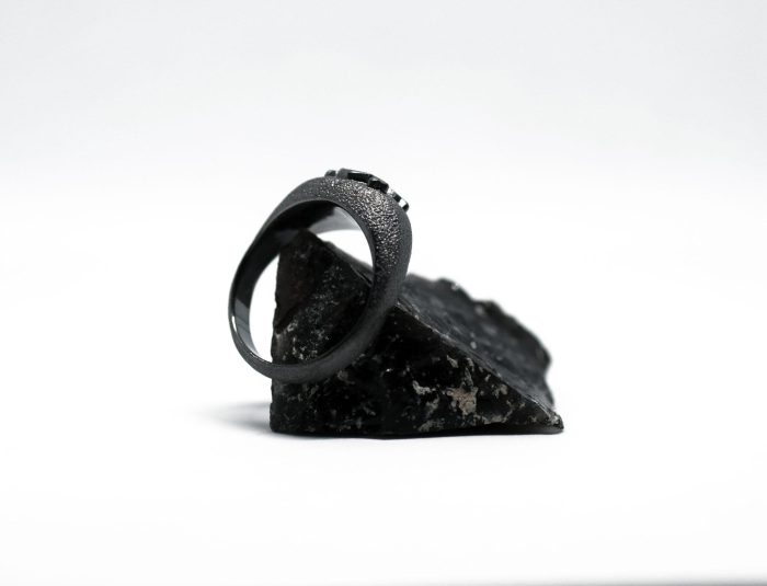 Ανδρικό δαχτυλίδι από ασήμι 925 βαθμών που έχει δεχθεί μαύρη επιπλατίνωση. Το δαχτυλίδι φέρει ένθετο έντεχνο χαρακτικό σχέδιο με νεκροκεφαλή. Κατασκευή της συλλογής ''Θυμήσου Σώμα''
