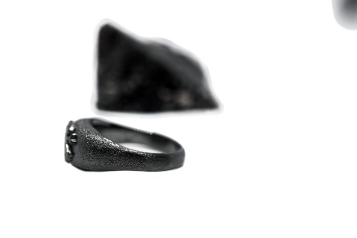 Ανδρικό δαχτυλίδι από ασήμι 925 βαθμών που έχει δεχθεί μαύρη επιπλατίνωση. Το δαχτυλίδι φέρει ένθετο έντεχνο χαρακτικό σχέδιο με νεκροκεφαλή. Σχεδιασμένο για τη συλλογή ''Θυμήσου Σώμα''