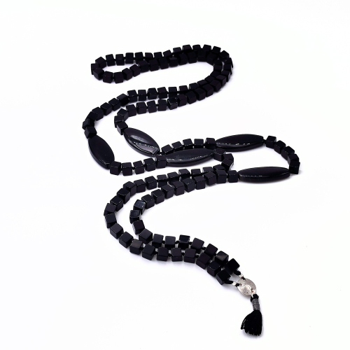 Γυναικείο κολιέ μακρύ, τύπου rope, με περίμετρο 96+4εκ. το κρεμαστό στοιχείo με το ασημένιο συνδετικό και βαμβακερό θύσανο σε μαύρο χρώμα. Απαρτίζεται από δεμένες χάντρες  όνυχα σε σχήμα κύβου 6mm, με διακόσμηση από χάντρες όνυχα σε σχήμα μαρκίζ  μεγέθους 3,5εκ . Όλα τα μεταλλικά στοιχεία είναι από ασήμι 925.